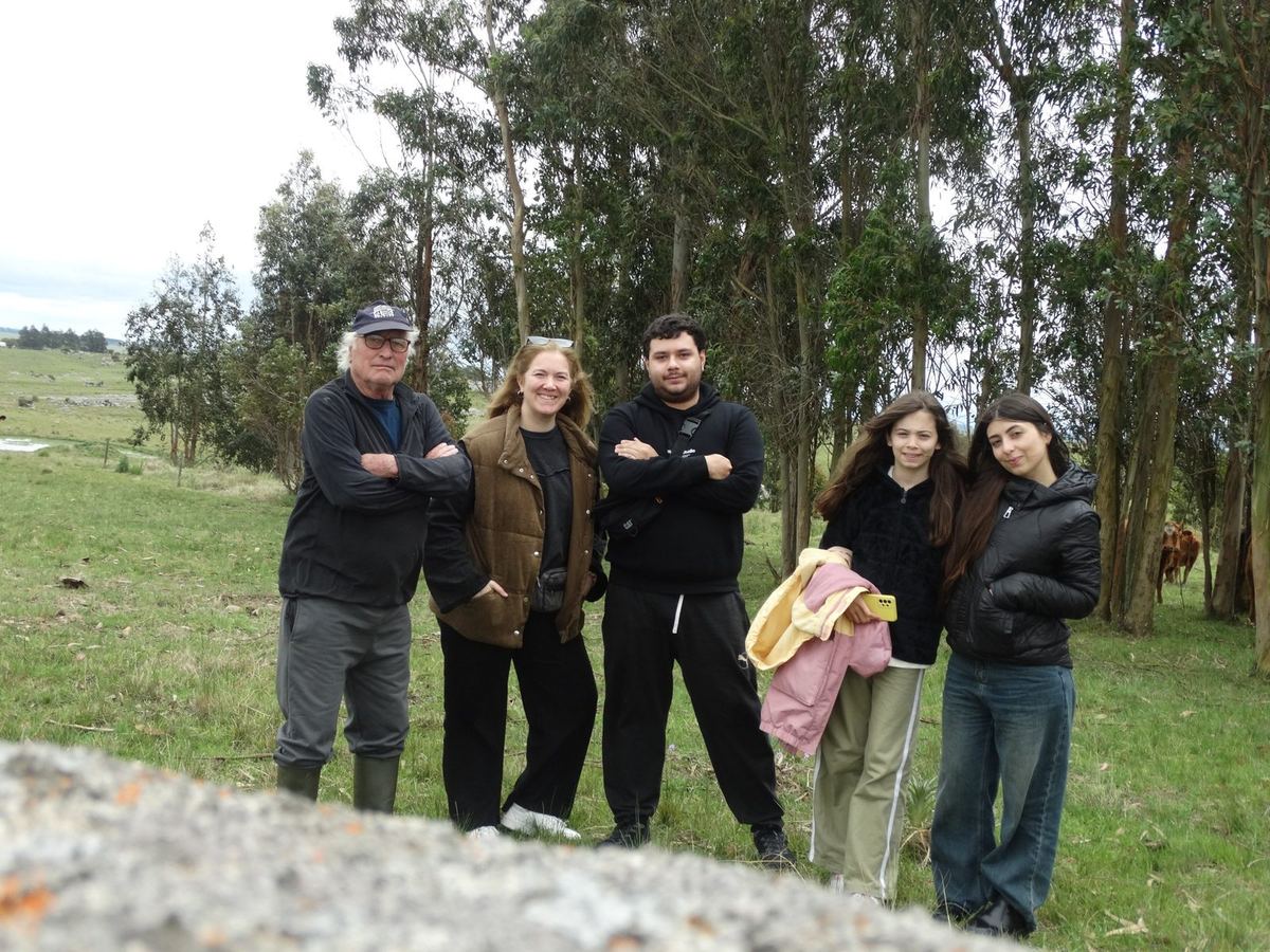 Grupo de personas junto al criador de ganado, entre eucaliptos